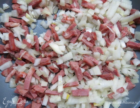 Репчатый лук мелко нарезать, после того как ветчина пустит сок, добавить в сковороду лук, жарить, помешивая, минут 5–7.