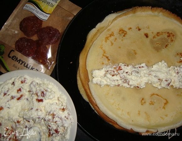 На середину каждого блинчика выложить дорожкой начинку и свернуть в трубочку.