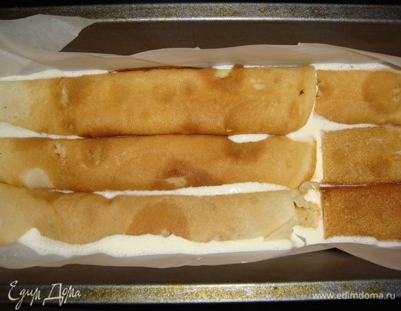 Форму застелить пергаментом, вылить 3-ю часть сметанной заливки, выложить первый слой блинных трубочек. Сверху залить их половиной оставшейся заливки, еще слой блинных трубочек. Сверху вылить оставшуюся заливку.