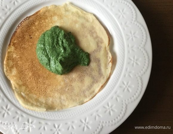 Выкладываем блин на тарелку, на блин — 2 столовые ложки шпинатной массы.