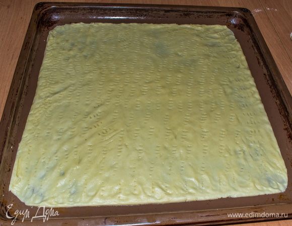 От замешанного теста нужно отделить небольшой кусок (размером с кулак) и поместить его в морозилку до полного замерзания ~15 минут. Оставшееся тесто раскатать на слегка смазанным маслом противне в толщину ~2-3 мм. Наколоть вилкой.