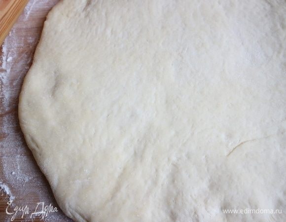 Духовку разогреть до 210°С. Тесто поместить на слегка посыпанную мукой поверхность, придать округлую форму, примерно того же размера, как дно формы для выпечки.