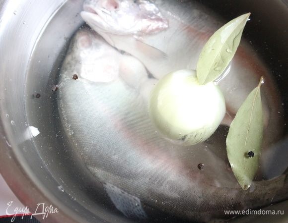 Положить форель в кастрюлю, залить холодной водой до отметки на кастрюле 2,9 литра. Добавить почищенную луковицу, перец горошком, лавровый лист. Поставить кастрюлю на сильный огонь, после закипания убавить огонь, снять пену, посолить. Во время варки крышкой не закрывать.