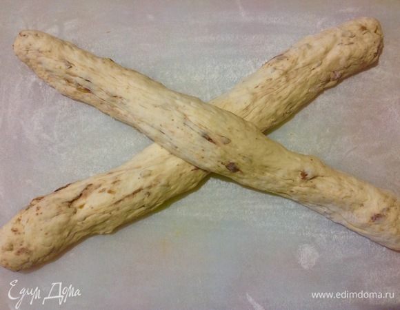 Каждую половинку скатываем в колбаску. Кладем крест накрест.