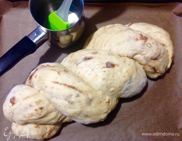 Теперь смазываем хлеб обычной водой комнатной температуры с помощью кисточки и быстро посыпаем кунжутом, чередуя черный и светлый.