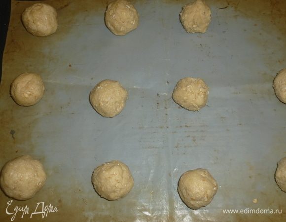 Сформировать шарики (12–15 штук). Можно смачивать руки холодной водой, чтобы легче было формировать. Шарики выложить на застеленный пергаментом противень на расстоянии друг от друга.
