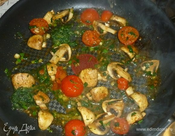 Добавить нарезанный зеленый лук, немного оливкового масла. Помидоры разрезать на половинки, добавить в сковороду. 
