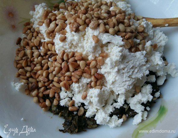 Добавить в шпинатную смесь рикотту, фету, кедровые орешки и мускатный орех, перец черный душистый. Кому необходимо, можете добавить соль. Все перемешать. Начинка готова. Тут я хочу сказать, что я начинку приготовила с вечера, а пекла уже на следующий день. Это очень удобно при нехватке времени.