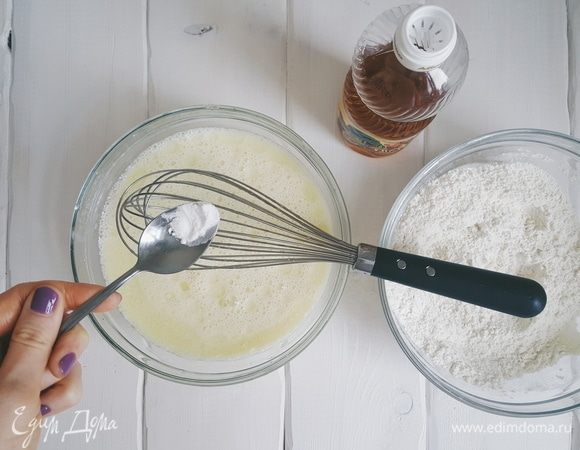 В другую миску добавляем молоко (2 ст. по 500 мл) и растительное масло. Взбиваем. И в эту же миску добавляем соду, гашеную яблочным уксусом.
