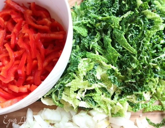 Листья капусты нарезать поперек тонкими полосками. Красный сладкий перец помыть, разрезать на половинки, удалить плодоножку, семенную часть, перегородки. Разрезать на четвертинки, нарезать поперек на тонкие полоски.