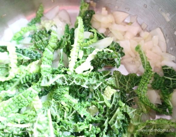 Лук и чеснок потушить в большой кастрюле с добавлением оливкового масла, лучше, если это будет кастрюля с толстым дном. Добавить савойскую капусту.