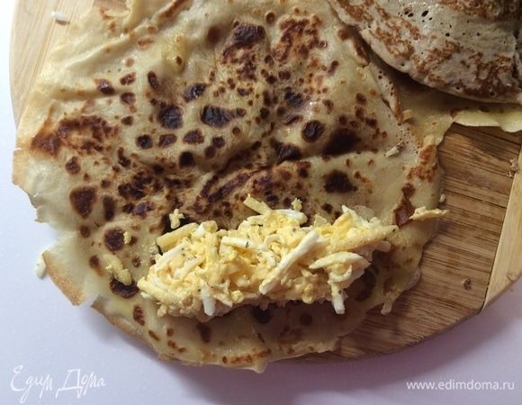 Фаршируем блины. Берем блинчик, выкладываем по одной его стороне мясную начинку и сворачиваем в плотный рулетик. Так сворачиваем всего 3 блинчика. Точно таким же образом фаршируем еще 3 блинчика сырной начинкой.