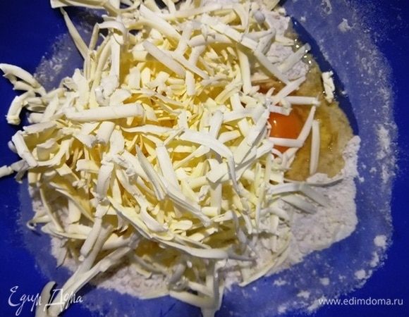 К смеси добавьте яйцо, сливочное масло, натертое на терке. Быстро перетрите тесто руками в крошку. Уберите в холодильник, пока готовите начинку.