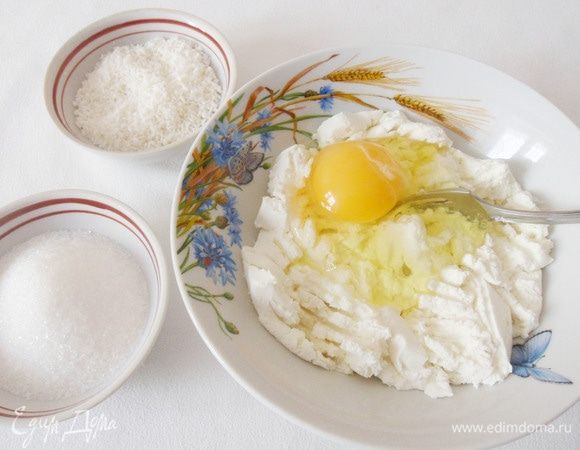 Пока хлебопечка трудится над приготовлением теста, есть время заняться начинкой для ватрушек. Соединить яйцо, кокосовую стружку, 50 граммов сахара и творог, измельченный вилкой.
