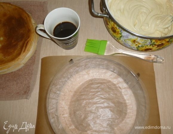 Для сборки я использовала регулируемое кондитерское кольцо и бордюрную ленту. Можете собрать торт в разъемной форме или без нее, просто он не будет таким ровненьким. Но это не суть. Выкладываем блинчик, смазываем кисточкой его кофе, наносим крем тонким слоем.