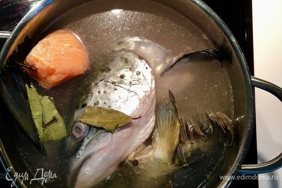 Сначала займемся бульоном. У меня было два рыбных суп-набора: головы и хвосты от карпа и семги. Я всегда использую эти непригодные для еды рыбные части, но именно они и создают весь аромат и колорит супа . Итак, 2 вида рыбы, а также филе семги без кости промываем и заливаем водой. Ставим на огонь, добавляем соль, перец горошком 5 шт., пару лавровых листов и пару гвоздичек. Когда бульон начинает закипать, образуется пена, снимаем ее и добавляем белое вино хорошего качества, у меня белое полусухое. Варим до готовности рыбы. Далее я в контейнер просто выловила и сложила всю рыбку, а бульон процедила.