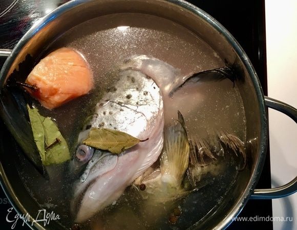 Сначала займемся бульоном. У меня было два рыбных суп-набора: головы и хвосты от карпа и семги. Я всегда использую эти непригодные для еды рыбные части, но именно они и создают весь аромат и колорит супа . Итак, 2 вида рыбы, а также филе семги без кости промываем и заливаем водой. Ставим на огонь, добавляем соль, перец горошком 5 шт., пару лавровых листов  и пару гвоздичек. Когда бульон начинает закипать, образуется пена, снимаем ее и добавляем белое вино хорошего качества, у меня белое полусухое. Варим до готовности рыбы. Далее я в контейнер просто выловила и сложила всю рыбку, а бульон процедила.