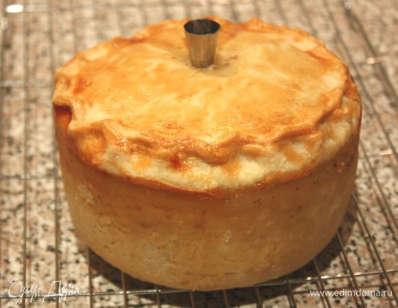 Желатин листовой замочить на 5 минут в холодной воде. Бульон разогреть в маленькой кастрюле. Желатин хорошо отжать и растворить в бульоне, затем перелить всё в молочник с удобным носиком). Вставить маленькую воронку в отверстие на пироге (можно использовать металлическую кондитерскую насадку для крема). Через воронку дробно вливать бульон до заполнения пирога. Если жидкость не уходит в пирог, можно длинной деревянной шпажкой аккуратно чуть расширить пространство между крышкой и начинкой. Оставить 3–4 ст. л. бульона для топпинга. Убрать пирог на холод не менее, чем на 2 часа.