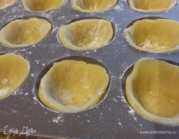Понадобятся формы для маффинов (у меня силиконовая, поэтому я не смазываю маслом и не посыпаю мукой). Тесто распределить по формам, обрезать лишние кусочки. Я раскатала тесто на пергаментной бумаге и выдавливала кружки подходящим по объему стаканом. Как на вареники. 