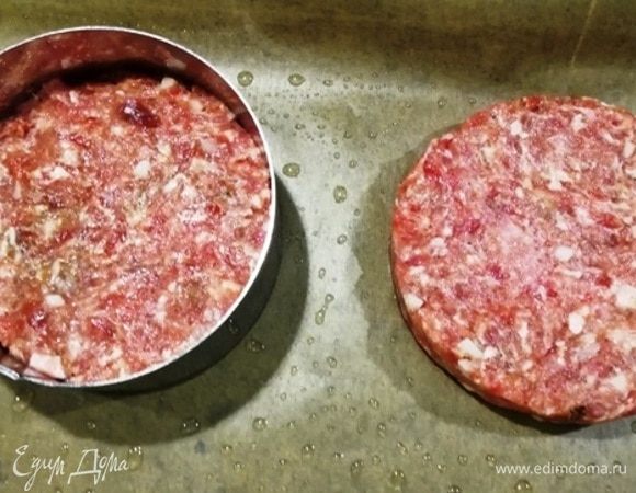 Мне нравится, чтобы все было одинакового размера. Застилаем противень бумагой для выпечки, смазываем маслом. Через кулинарное кольцо формируем бифштексы.