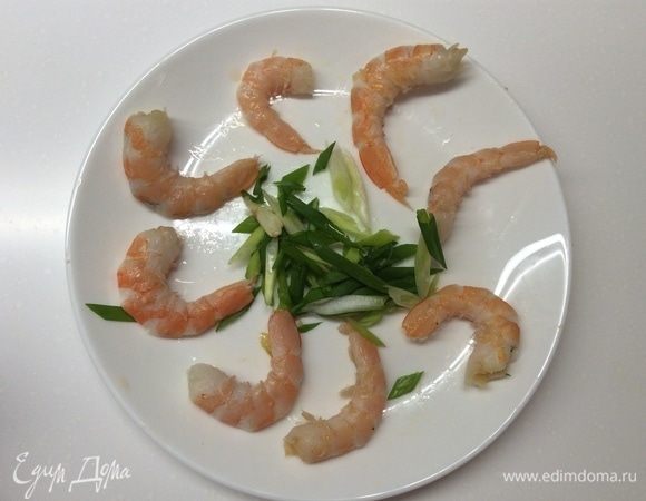 Креветки почистить после разморозки. Нарезать зеленый лучок по диагонали и отправить в суп. Оставить до закипания. Тем временем отварить рисовую лапшу согласно инструкции на упаковке.