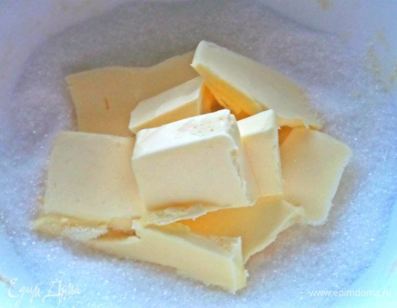 Мягкое масло покрошить в сахар.