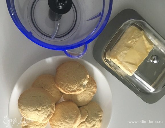 Приготовим сперва основу тарта. Для этого нам необходимо любое песочное печенье. Когда у меня остается лишнее песочное тесто, я пеку из него обычное печенье любой формы и оставляю для таких случаев. В данном случае пошаговых фот для этого конкретного печенья, к сожалению, я не сделала, но в ингредиентах состав расписала. Просто замесила из ингредиентов тесто в комочек, на полчасика в холодильник убрала, а потом кругленькие печеньки напекла. Итак, нам понадобится домашнее печенье и размягченное сливочное масло, печенье измельчить в крошку с помощью блендера, нам понадобиться 1 стакан. Печенье смешиваем с размягченным маслом.