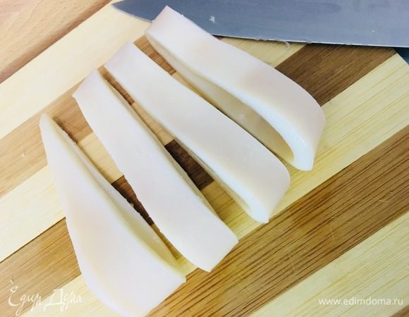 Отварной кальмар нарезать крупными кольцами.