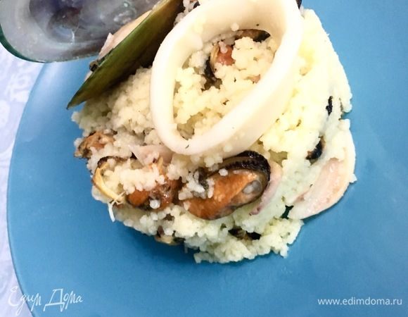 Добавить готовый кускус в сковороду. Посолить по вкусу, добавить щепотку прованских трав для легкого аромата и все хорошо перемешать. Готовить на среднем огне 3-4 минуты без зажаривания. Выложить в порционнные тарелки и украсить мидиями в ракушках. Приятного аппетита!