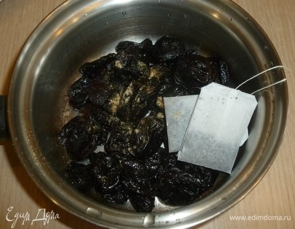 Чернослив, пакетики с чаем, имбирь и гвоздику сложить в сотейник, залить кипятком, чтобы чернослив был полностью в воде. Оставить на 10 минут, воду слить.