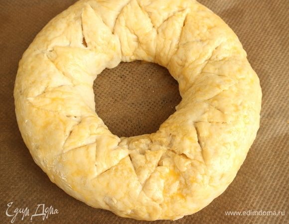Острым ножом надрезать верхнюю часть пирога по кругу на 0,5 см в глубину так, чтобы получилась изломанная треугольниками линия. Это делается не только для красоты, но еще для выхода пара. Противень с пирогом поместить в духовку на 35–45 минут. 