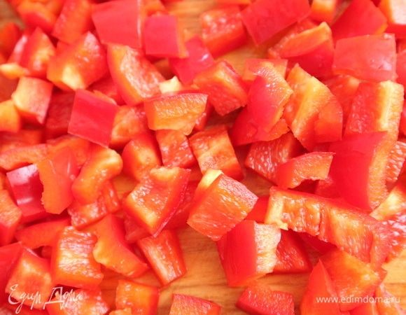 Перец болгарский очистить от семенной части, плодоножки, разрезать на четвертинки, порезать кубиками. Готовила с красным болгарским перцем, можно использовать зеленый. Чеснок почистить, выдавить через пресс. 