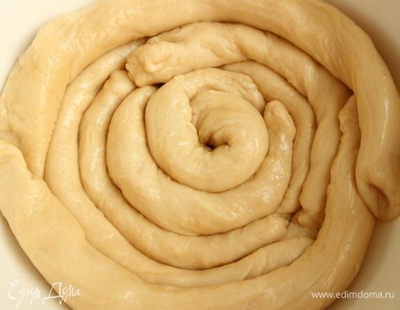 Тесто немного размять руками в лепешку, нарезать на короткие полосы и скатать каждую из них в жгут 3 см толщиной. Обмазать растительным маслом, сложить в миску по кругу, накрыть крышкой (тарелкой), оставить на 30 минут.