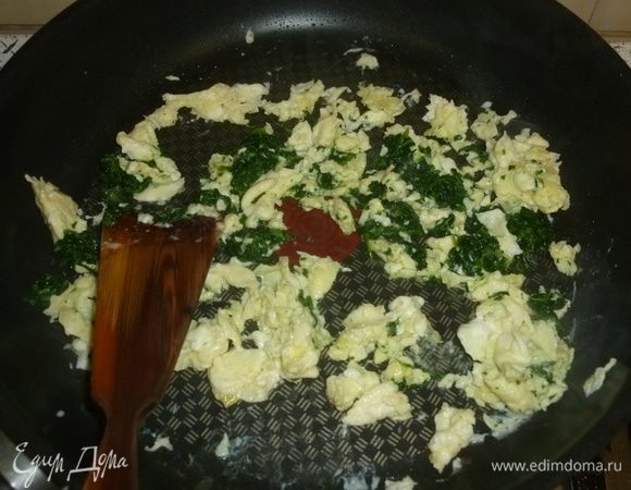 Разогреть сковороду, смазать ее оливковым маслом. Выложить шпинат. Жарить, помешивая. Яйца вылить в сковороду.