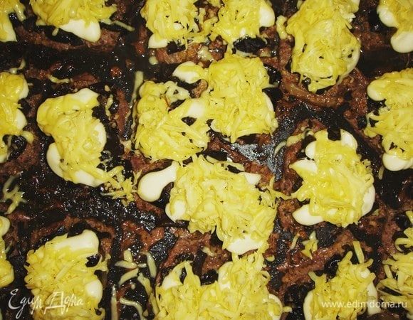 Вынуть отбивные из духовки, посыпать натертым на крупной терке сыром и запекать еще 10 минут до золотистой корочки.