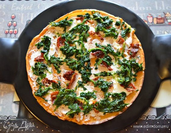 Собираем наш закусочный торт: на блюдо выложить блин, смазать слегка творожным сыром, выложить кусочки томатов, шпинат.