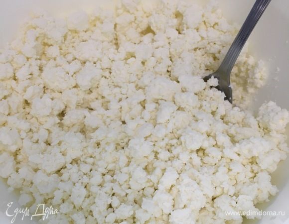 Разморозить тесто. Выложить творог в глубокую емкость и растереть его.