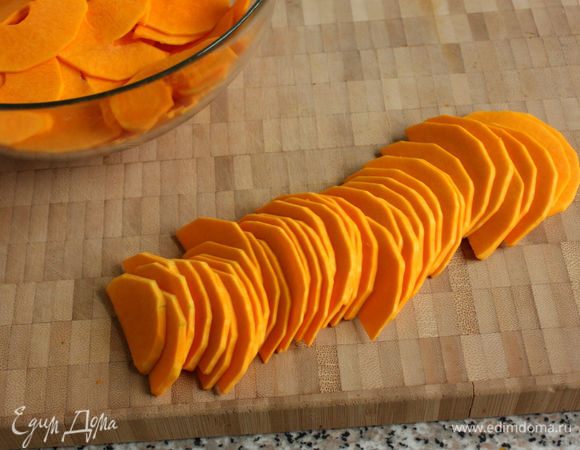 Очистить кожуру и нарезать тыкву поперек тонкими (по 1 мм) пластинами. Это легко сделать овощечисткой или кухонным комбайном, теркой-мандолиной.