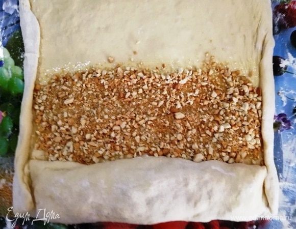 Распределите на масле арахисовую начинку. Края подверните.