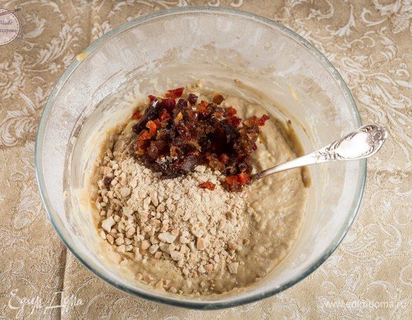 Добавить орехи и цукаты в тесто. Перемешать. Переложить тесто в форму для кекса. Выпекать в предварительно разогретой духовке (180°С) около 50 минут.