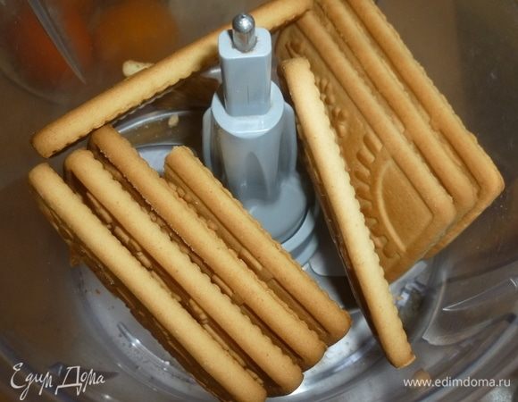 Печенье измельчить в мелкую крошку. Отложить 1 ст. л. крошки для украшения. Остальное смешать с растопленной массой.