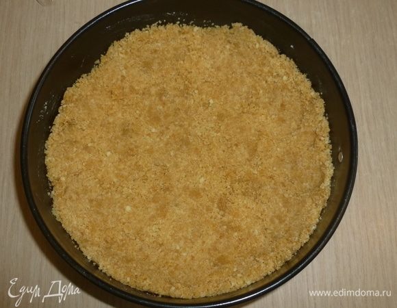 Основу выложить в форму, утрамбовать ложкой, формируя небольшой бортик.