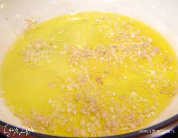 Разогреть в тяжелой глубокой сковороде оливковое масло и обжарить лук.