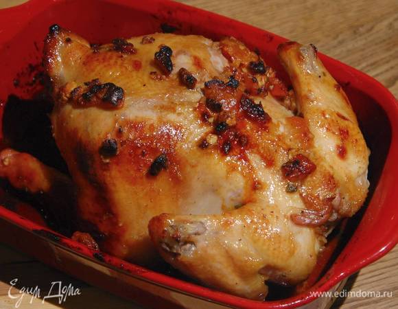 Запекать курицу в разогретой духовке 15 минут, затем понизить температуру до 170°С и запекать до готовности, примерно еще 45 минут, периодически поливая выделившимся соком.