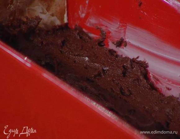 Продолговатую форму для выпечки выстелить пищевой бумагой, смазать оставшимся сливочным маслом, выложить тесто и разровнять его.