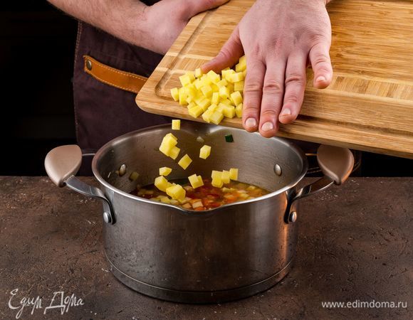 Добавьте нарезанный кубиками картофель, посолите и варите на медленном огне до готовности картофеля.