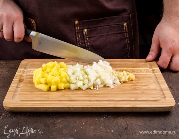 Нарежьте мелко лук и сельдерей, измельчите чеснок. Картофель нарежьте кубиками.