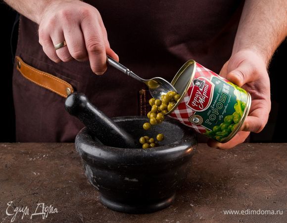 Добавьте к фисташкам консервированный зеленый горошек ТМ «Фрау Марта», сыр, чеснок, влейте немного оливкового масла и измельчите до однородности.