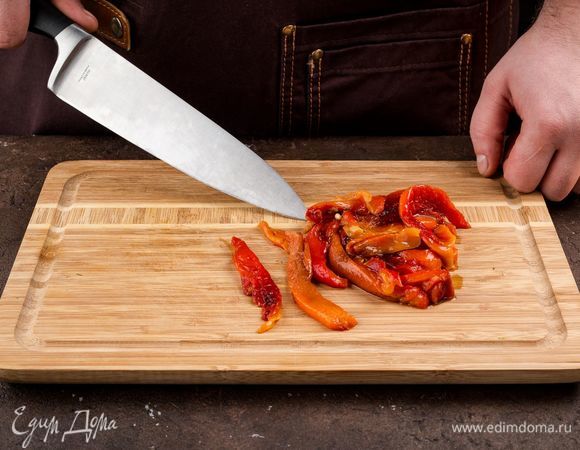 Болгарский перец запеките в духовке, снимите кожицу и нарежьте полосками.