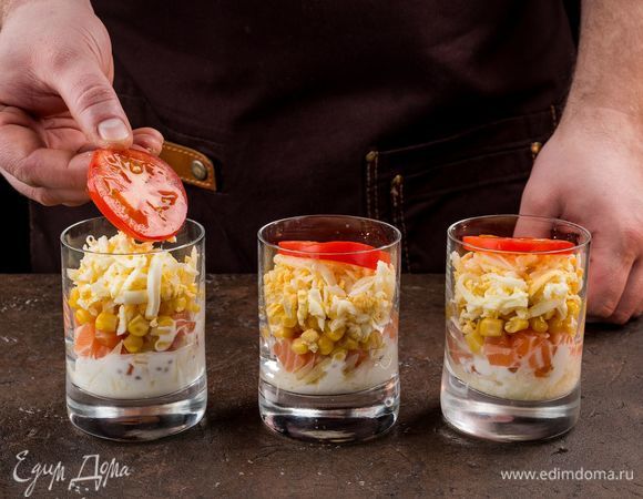 Яйца выложите сверху на слой кукурузы. Помидор нарежьте кружочками и украсьте салат.